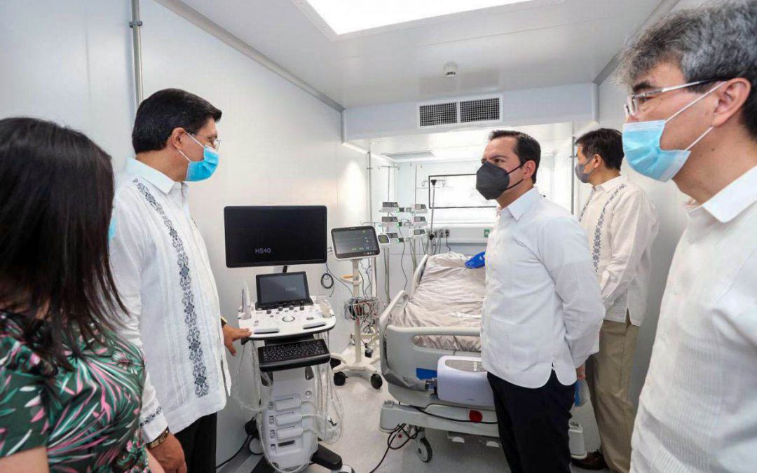 El gobernador del estado de Yucatán, Mauricio Vila Dosal, escucha con atención la explicación del embajador japonés Takashi Manabe las virtudes de la Unidad de Atención de Pacientes críticos equipada con tecnología de punta.