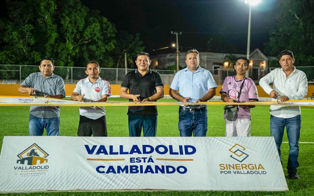 El presidente municipal, Alfredo Fernández Arceo, acompañado por el secretario de la comuna corta el listón inaugural del remodelado campo de futbol de la colonia Emiliano Zapata.